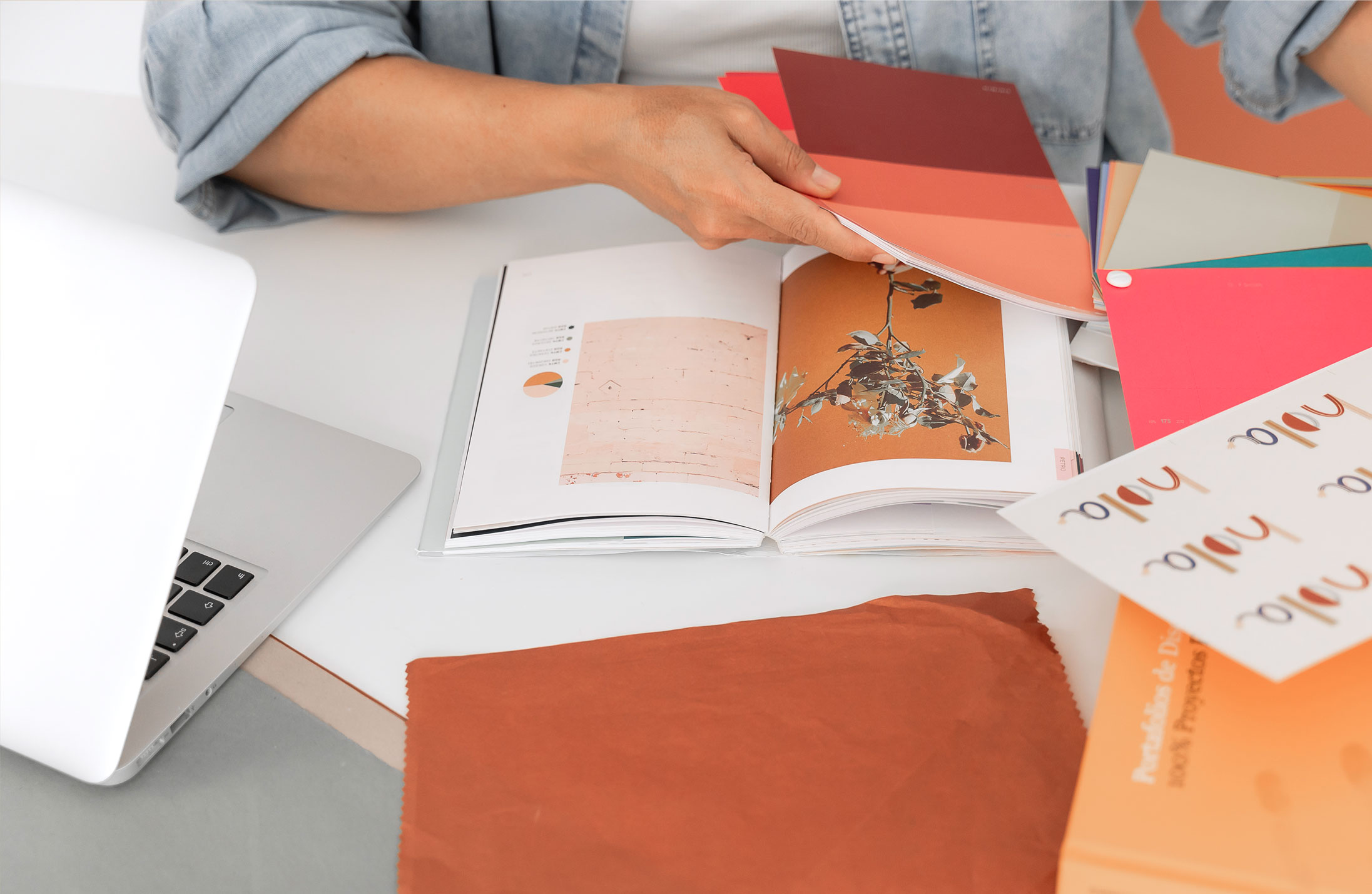 Imagen trabajando en la mesa del estudio con diversos materiales, libros y recursos
